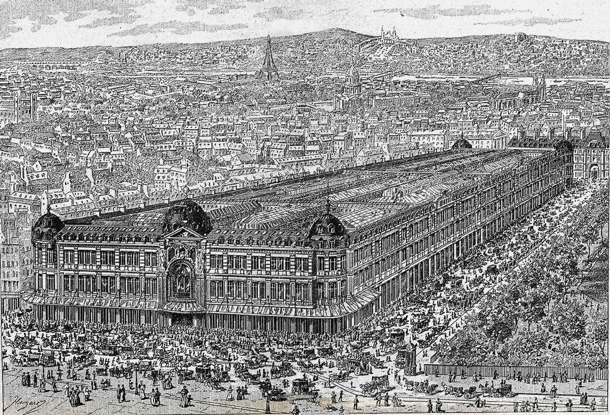 A bird's-eye engraving of the Bon Marché department store in Paris, a long building filling a whole block, crowds and carriages in the streets around it.