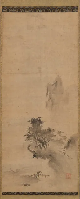 A tall hanging scroll on which loose splashes of wet ink suggest a mountain, trees and a small building in mist.