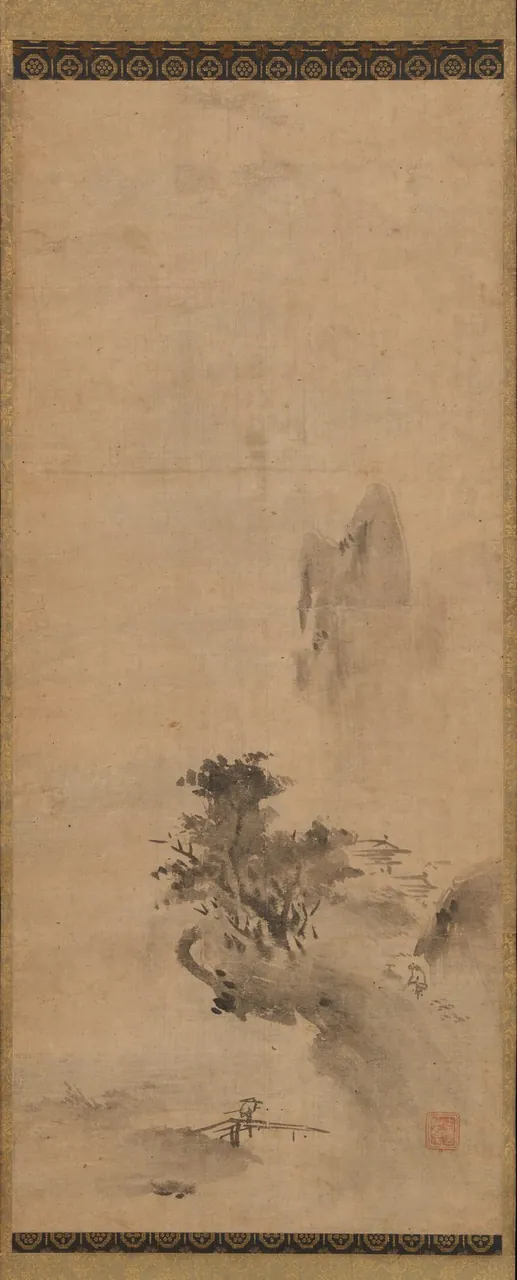 A tall hanging scroll on which loose splashes of wet ink suggest a mountain, trees and a small building in mist.
