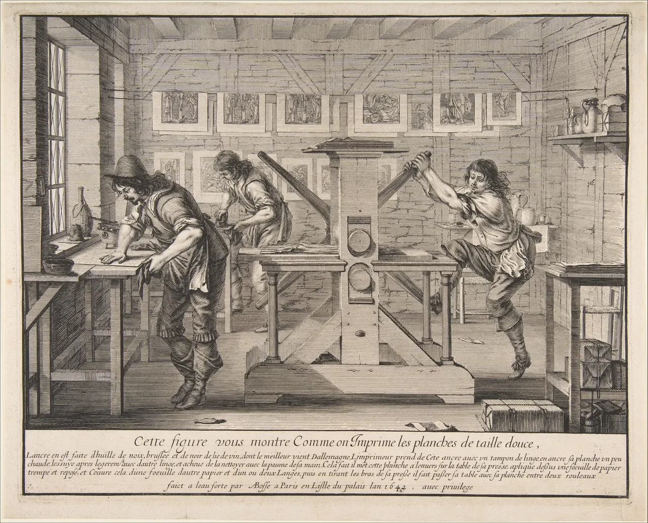 An etching of a print workshop: one printer inks a plate at a table while another pulls hard on the spokes of a big wooden press, finished prints drying overhead.