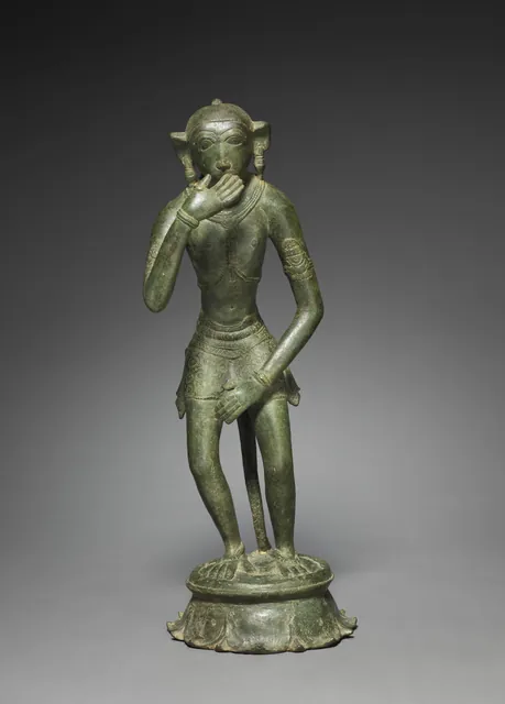 A green-patinated bronze of Hanuman standing on a lotus base, one hand raised to his mouth in a gesture of respectful speech.