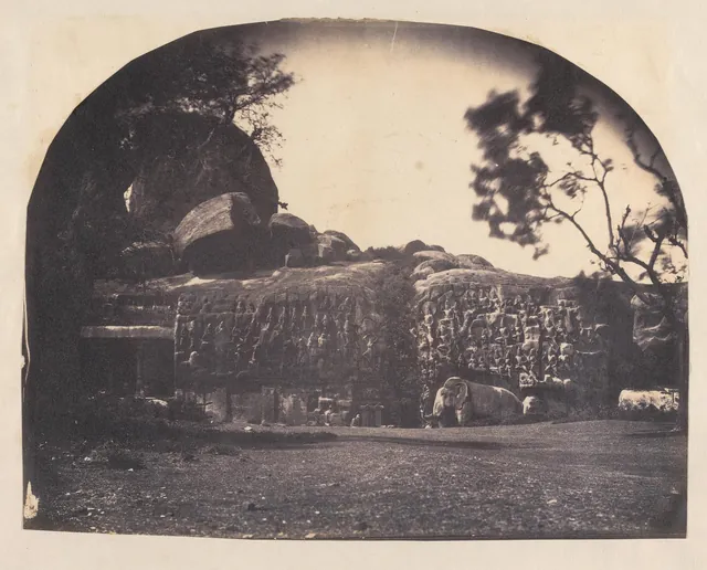 An 1858 photograph of the great carved rock face at Mamallapuram, a long granite relief split down the middle by a natural cleft, with a life-size elephant at its base.